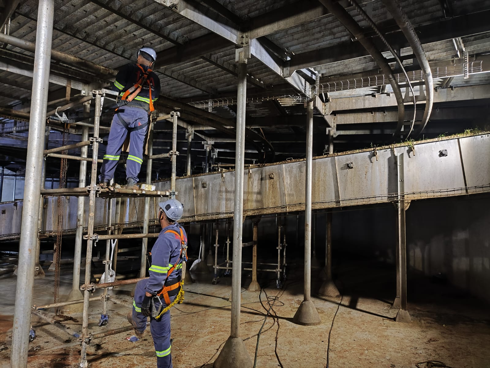 Equipe JR com EPI completo executando montagem industrial em andaime